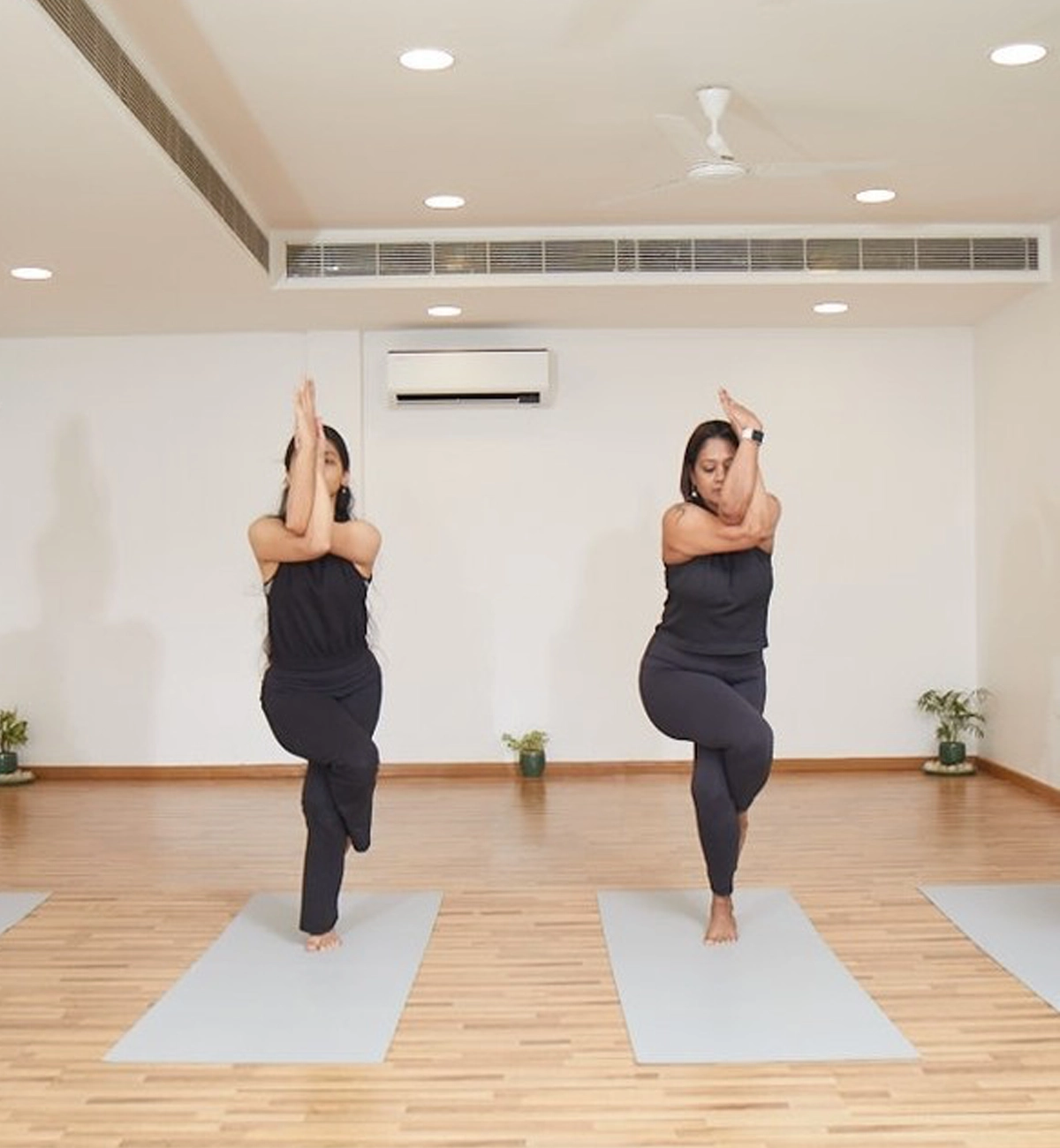 Two women practicing yoga in a studio