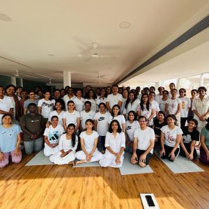 A large group of people posing together in a yoga studio