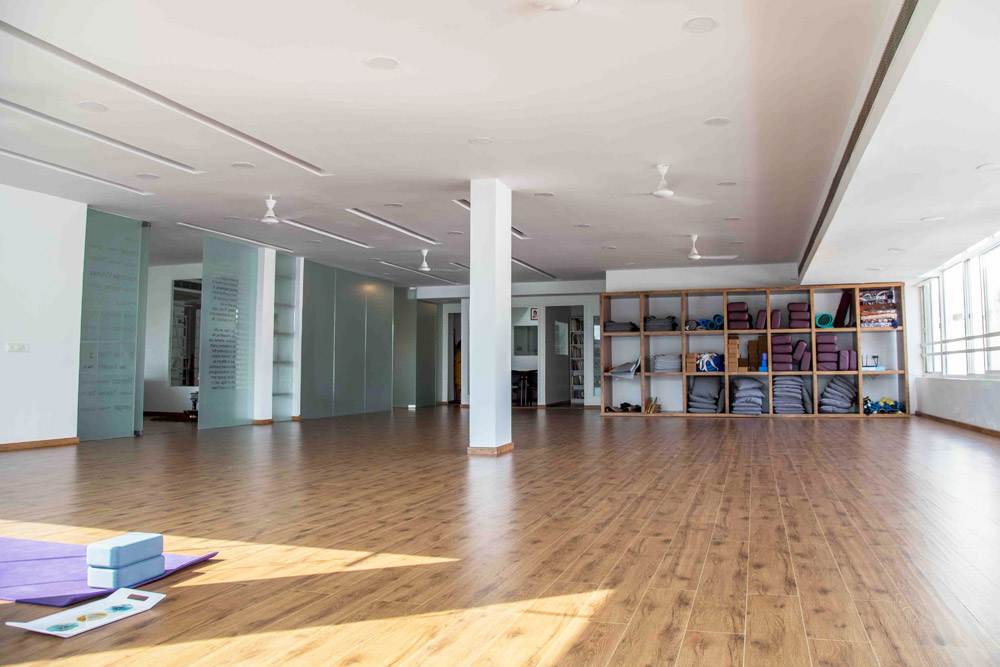 A spacious and bright yoga studio with wooden floors